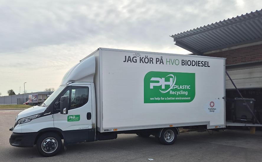 Vit lätt lastbil med en grön logotyp för ph plastic recycling på skåpet.