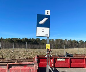 Bilden visar en skylt för fraktionen för trä på en återvinningscentral. 