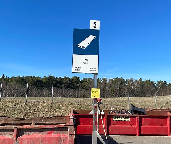 Bilden visar en skylt för fraktionen för trä på en återvinningscentral.