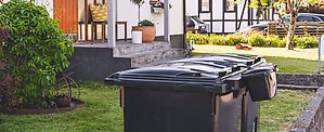 FNI-kärl 1 och 2 utanför ett hus. På ett av kärlen hänger en elektronikbox.