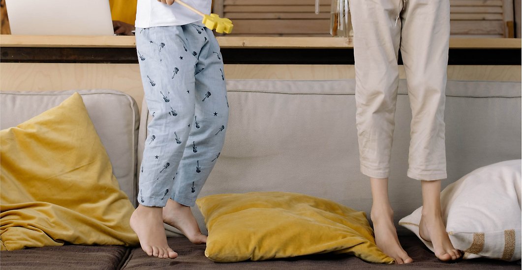Två barn hoppar i en soffa.