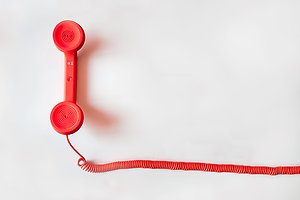 Röd trådad telefonlur.