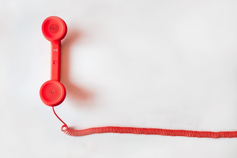 Röd trådad telefonlur.